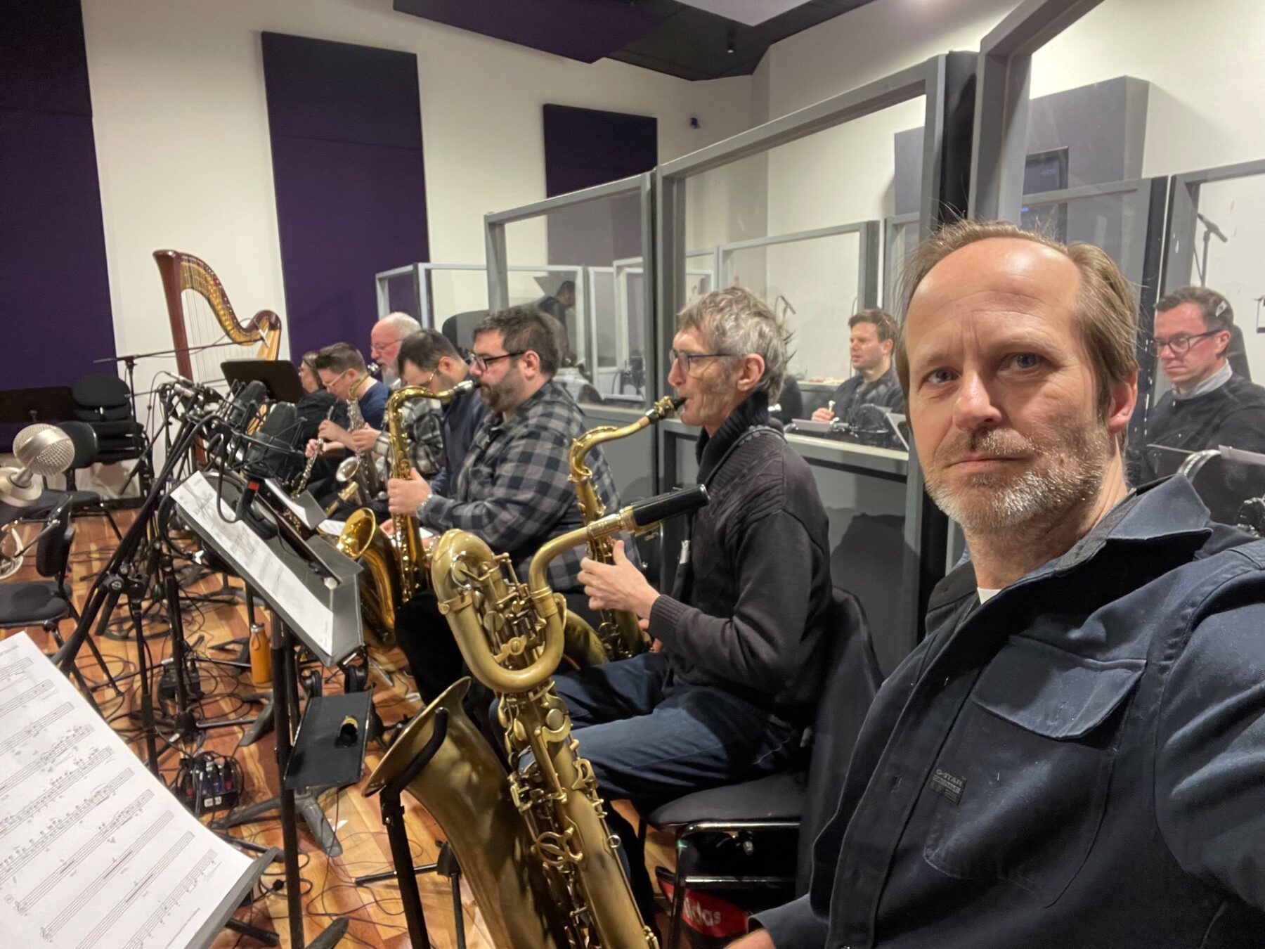 Remco Keijzer seated with a saxophone section during a rehearsal