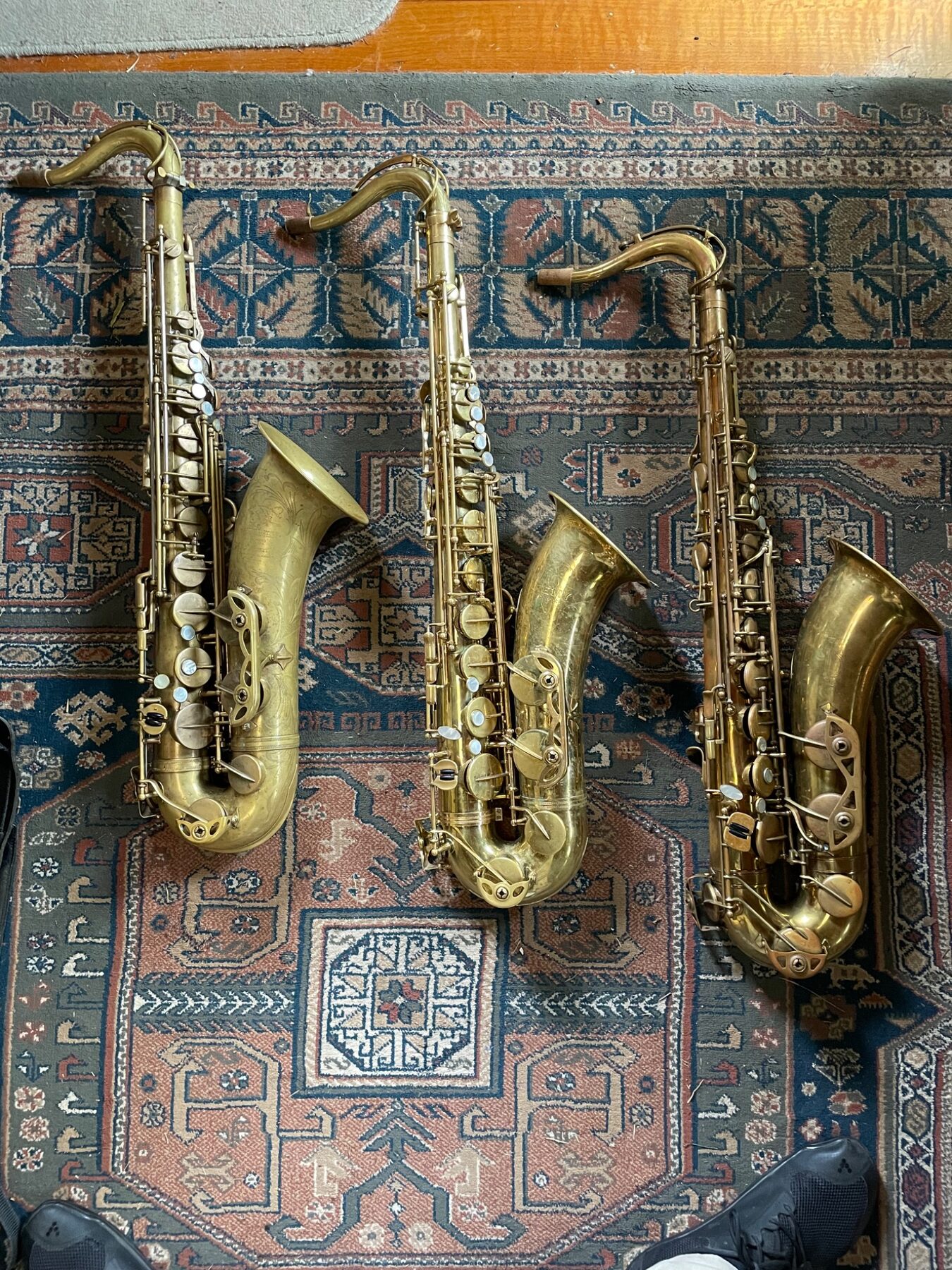 Four saxophones arranged on a patterned rug